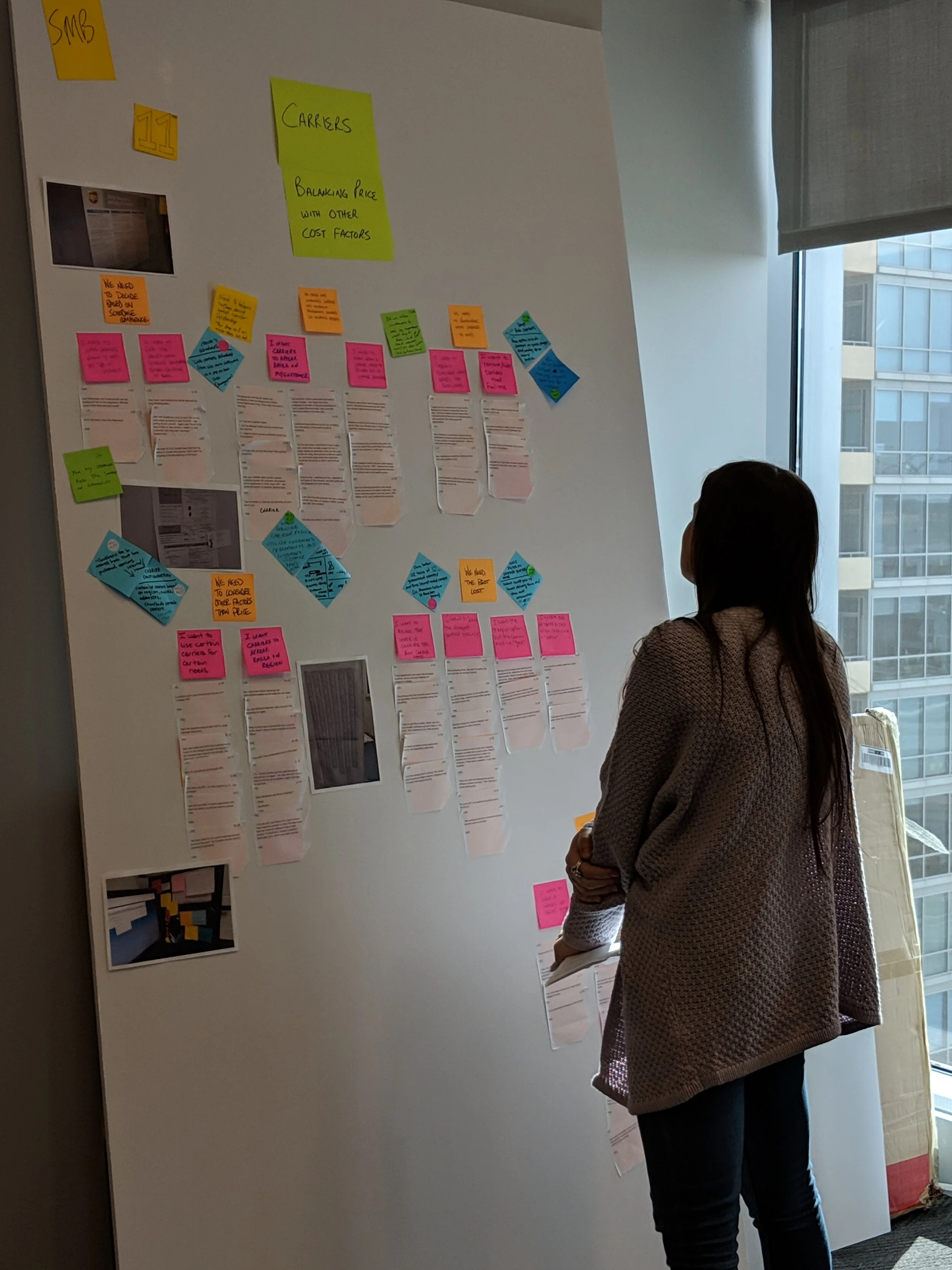 Stakeholder reviewing synthesized research on the workshop wall
